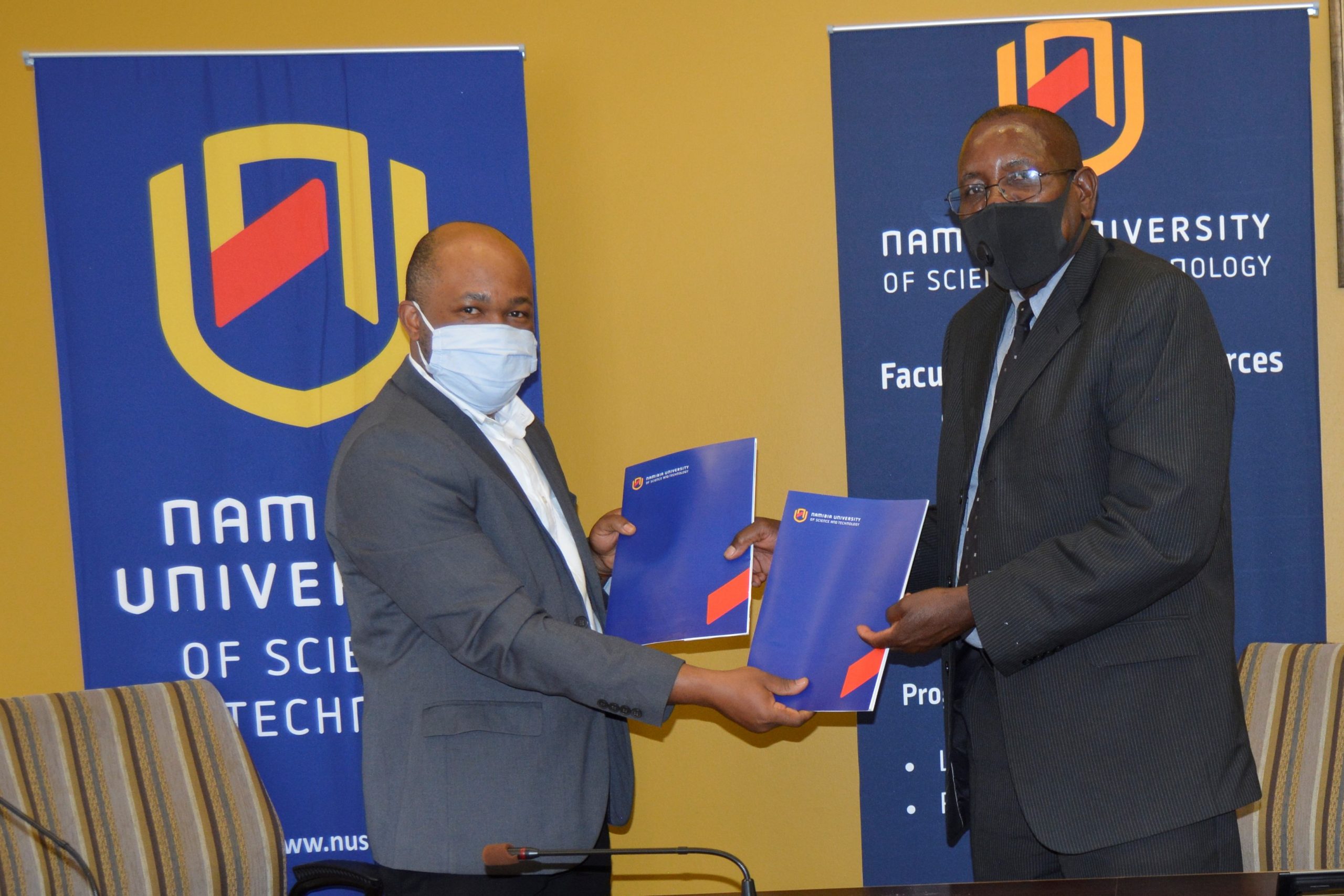 Prof Uchendu Chigbu (left) receives the signed GLTN Partners' Charter from the Acting Vice Chancellor, Namibia University of Science and Technology (NUST)